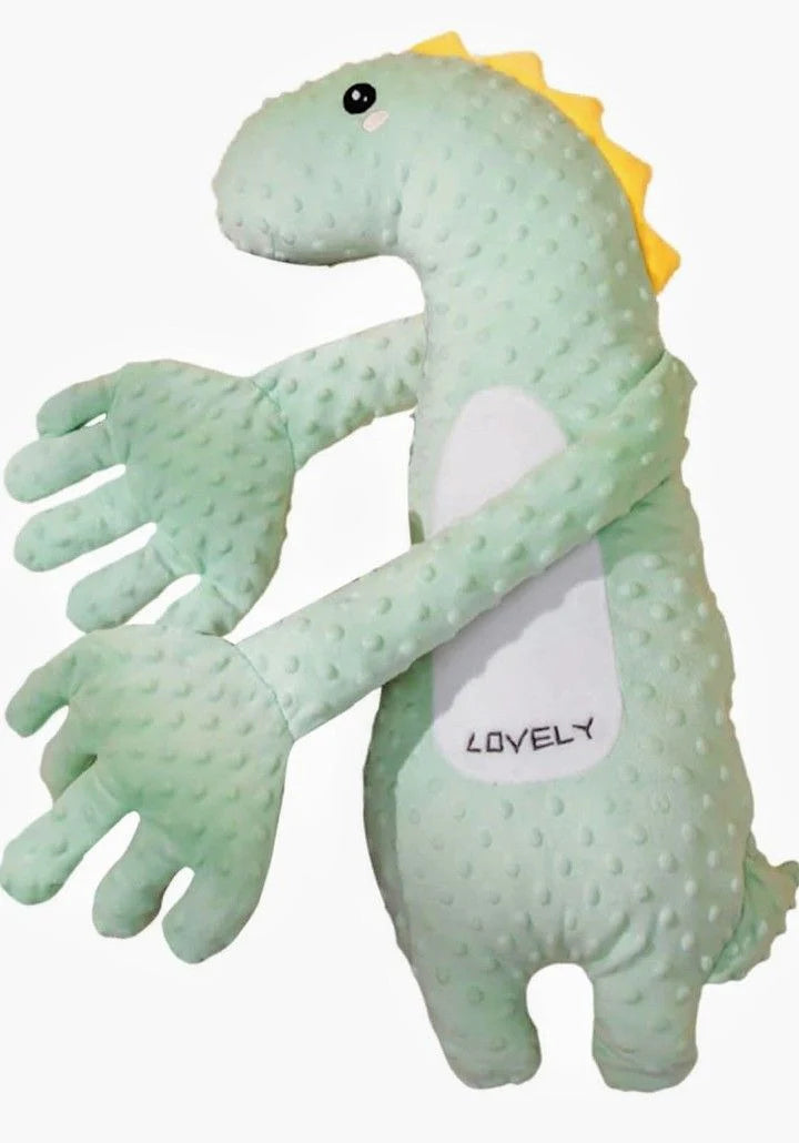A light green textured plush dinosaur toy with a yellow spiky back, black eyes, and a white belly patch that reads 'LOVELY' in black text, shown against a plain white background.